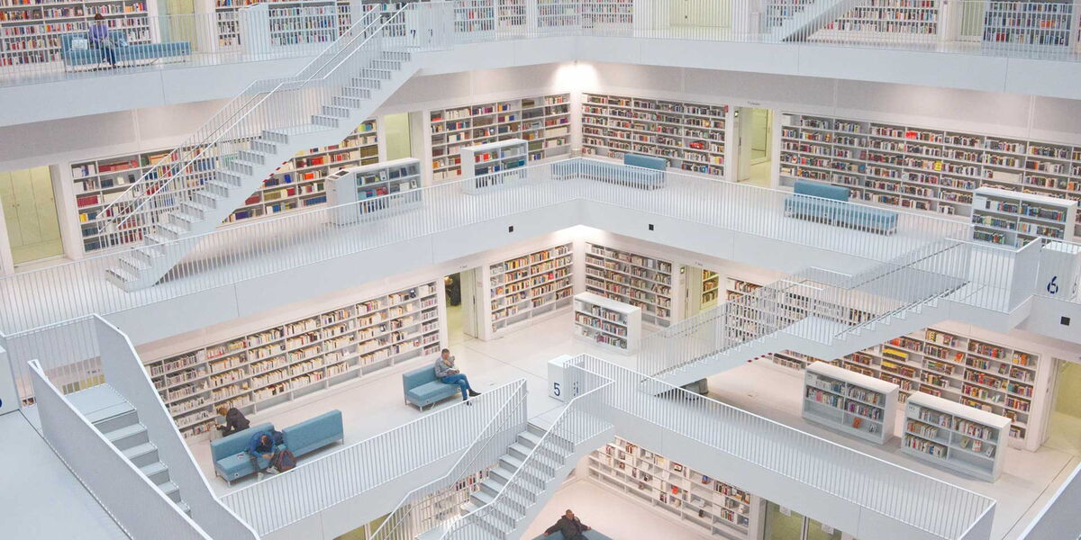 Eine große weiße Bibliothek mit Menschen und Büchern