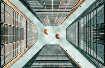 Heißluftballons, von unten fotografiert, über vier Hochhäuser