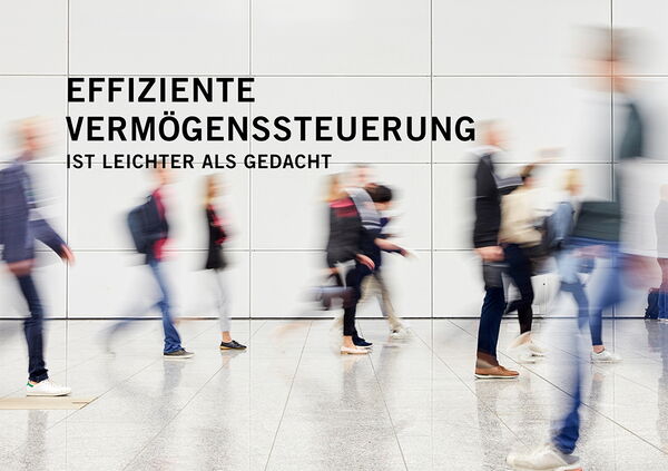 Menschen laufen vor einer weißen Wand entlang. Die Aufnahme ist verrschwommen