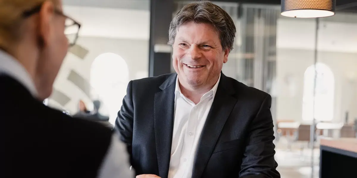 Ein Mann berät freudig eine Kundin