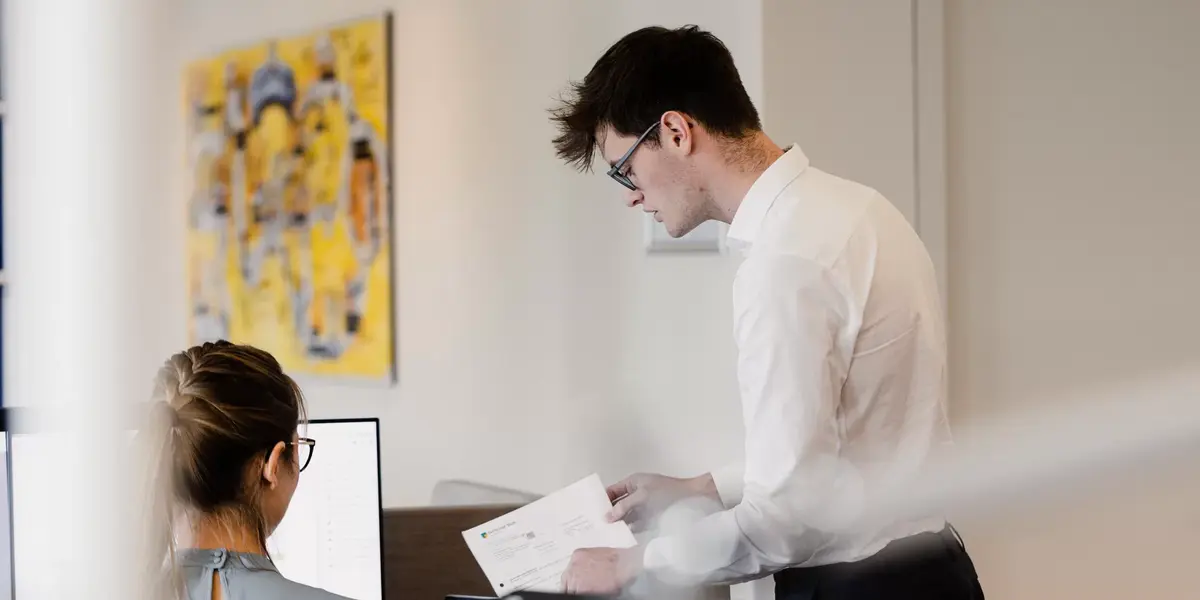Ein Mann und eine Frau bei Kontora reden an einem Schreibtisch