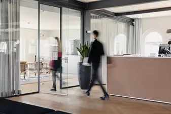 Menschen gehen durch das Kontora Family Office, die Aufnahme ist verschwommen.