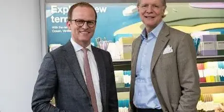 Patrick Maurenbrecher und Axel St&uuml;rken stehen vor einem Schreibwarenregal und gucken in die Kamera