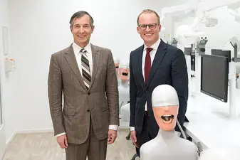 Maurenbrecher und Muehlbauer stehen im Labor und gucken in die Kamera