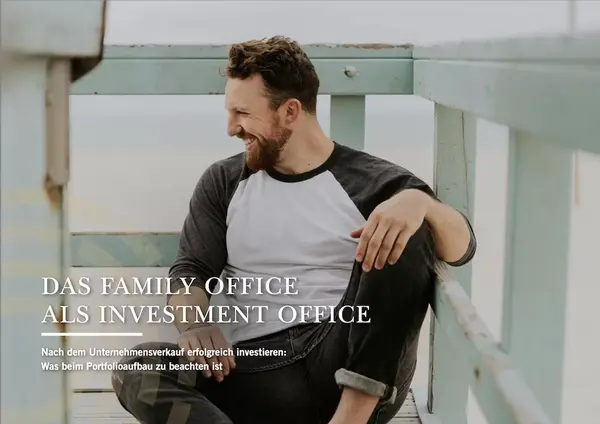 Ein Mann sitzt auf einem Holzger&uuml;st und guckt freudig zur Seite