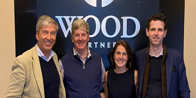 Vier Menschen stehen vor dem Logo von Wood Partners