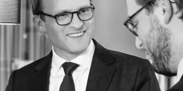 Patrick Maurenbrecher l&auml;chelt seinen Gespr&auml;chspartner an, Schwarzwei&szlig;aufnahme