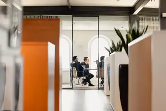 Ein Blick durch eine Glasscheibe in ein Meeting