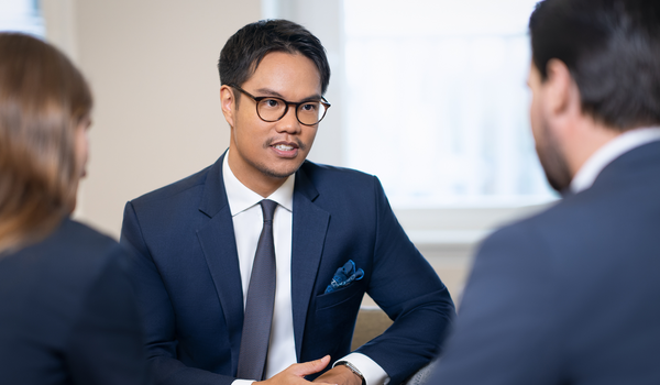 A man is talking with two colleagues