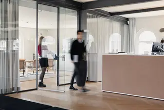 Zwei Leute gehen durch das Kontora Family Office. Die Bewegung ist verwischt.