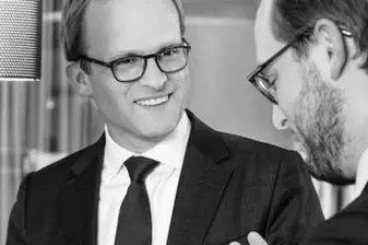 Patrick Maurenbrecher lächelt seinen Gesprächspartner an, Schwarzweißaufnahme